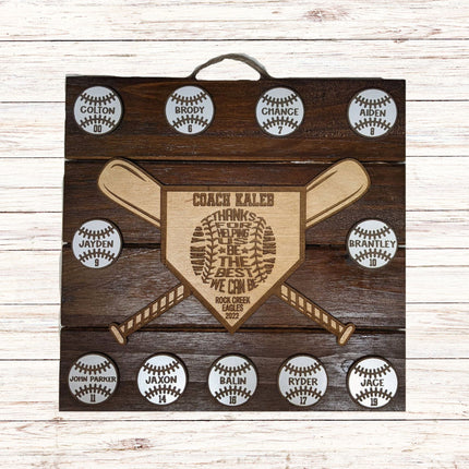 Wooden plaque with engraved text and baseball designs on a wooden background