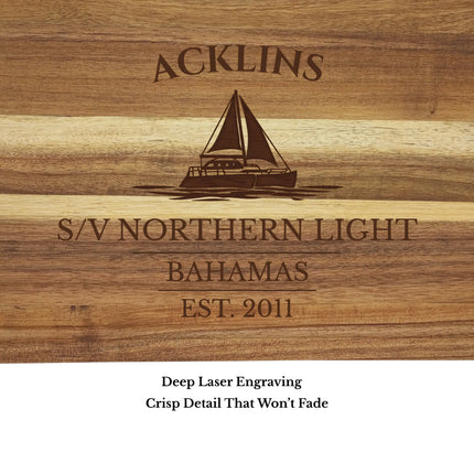 Close up of Acklins Bahamas sailboat cutting board engraving showing detailed sailboat design and acacia wood grain