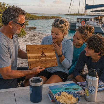 Andros Bahamas personalized cutting board being shared between offshore cruising family members beside a remote tropical anchorage and expedition sailboat