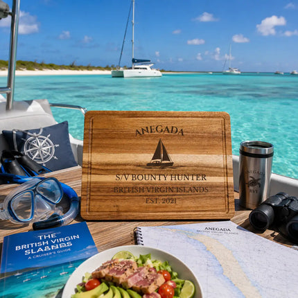 Anegada British Virgin Islands sailboat cutting board displayed aboard a catamaran in shallow turquoise Caribbean waters beside remote white sand beaches and open island horizons