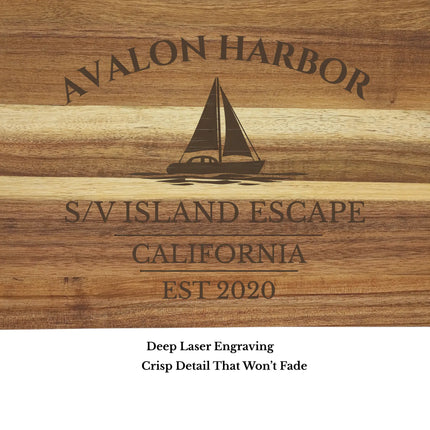 Close up of Avalon Harbor California sailboat cutting board engraving showing detailed laser etched sailboat design and acacia wood grain