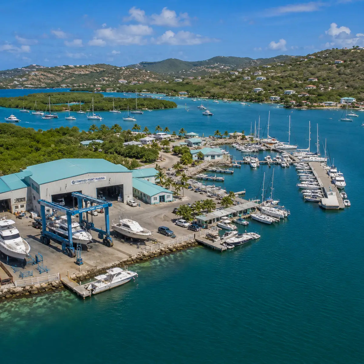 Compass Point Marina and marine service facilities at Benner Bay Harbor with docks, haul-out equipment, and cruising yachts.