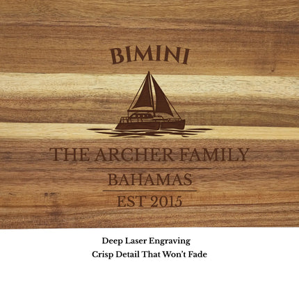 Close up of Bimini Bahamas sailboat cutting board engraving showing detailed sailboat design and acacia wood grain