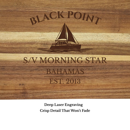 Close up of Black Point Bahamas sailboat cutting board engraving showing detailed sailboat design and acacia wood grain