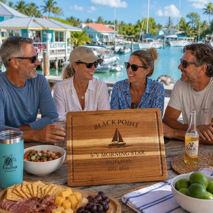 Black Point Bahamas personalized cutting board being used during a relaxed waterfront gathering with cruisers and sailboats in the Exumas