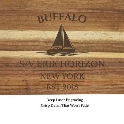 Close up of engraved sailboat design and personalized text on Buffalo New York nautical cutting board showing detailed wood grain