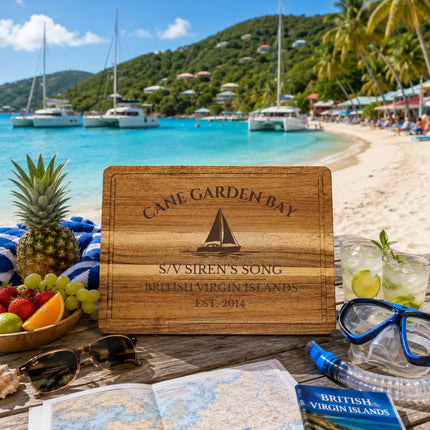 Cane Garden Bay British Virgin Islands sailboat cutting board displayed beside turquoise Caribbean water white sand beaches anchored catamarans and lush tropical Tortola scenery