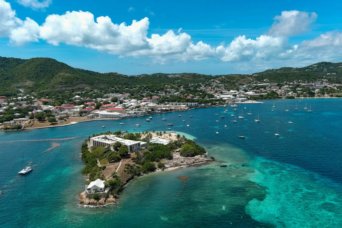 Aerial view of Christiansted Harbor on St. Croix, U.S. Virgin Islands, featuring Protestant Cay, anchored sailboats, turquoise Caribbean waters, and the historic waterfront.