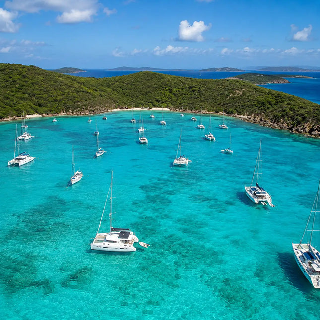 Sailboats anchored in the protected turquoise waters of Christmas Cove beside Great Saint James.