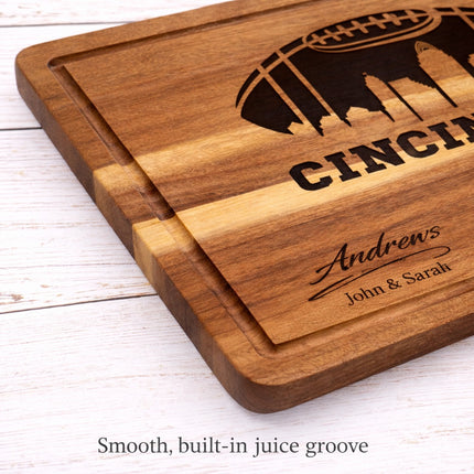 Close-up of Cincinnati football cutting board showing smooth built-in juice groove, solid acacia wood with deep natural laser engraving