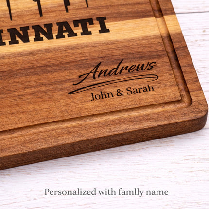 Close-up of personalized Cincinnati football cutting board showing custom family name engraving in solid acacia wood