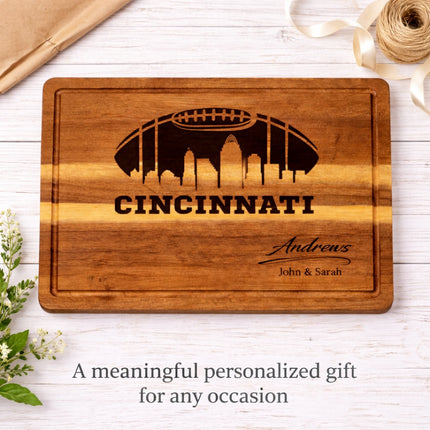 Cincinnati football cutting board displayed as a personalized gift, solid acacia wood with laser engraved skyline and custom family name