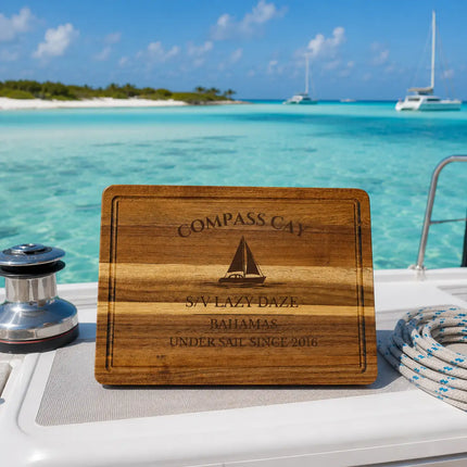 Compass Cay Bahamas sailboat cutting board overlooking shallow turquoise Exumas water with sandbars and anchored cruising catamarans