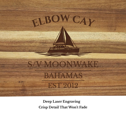 Close up of Elbow Cay Bahamas sailboat cutting board engraving showing detailed sailboat design and acacia wood grain