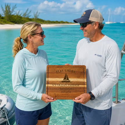 Eleuthera Bahamas personalized cutting board being exchanged as a gift beside turquoise Bahamian water and tropical island coastline