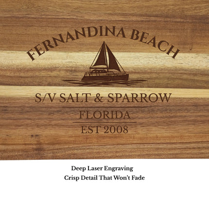 Close up of Fernandina Beach Florida sailboat cutting board engraving showing detailed sailboat design and acacia wood grain