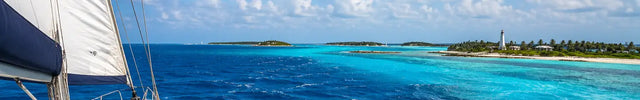 Offshore sailboat crossing turquoise Gulf Stream waters from Florida toward the Bahamas under bright tropical skies