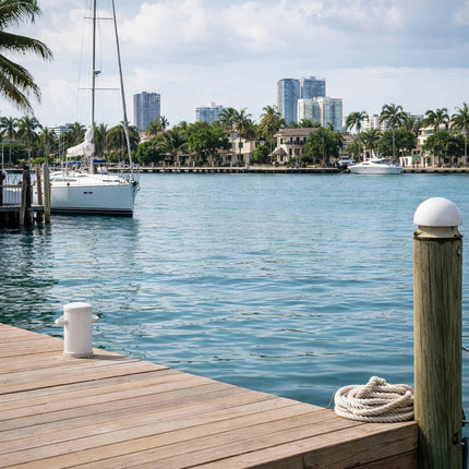 Fort Lauderdale Intracoastal Waterway marina scene with sailboats, palm-lined waterfront homes, and city skyline, representing the coastal boating culture behind the custom cutting board