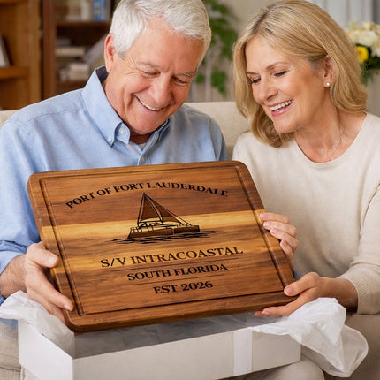 Personalized Fort Lauderdale sailboat cutting board being opened as a gift, showing engraved boat name, home port, and established year