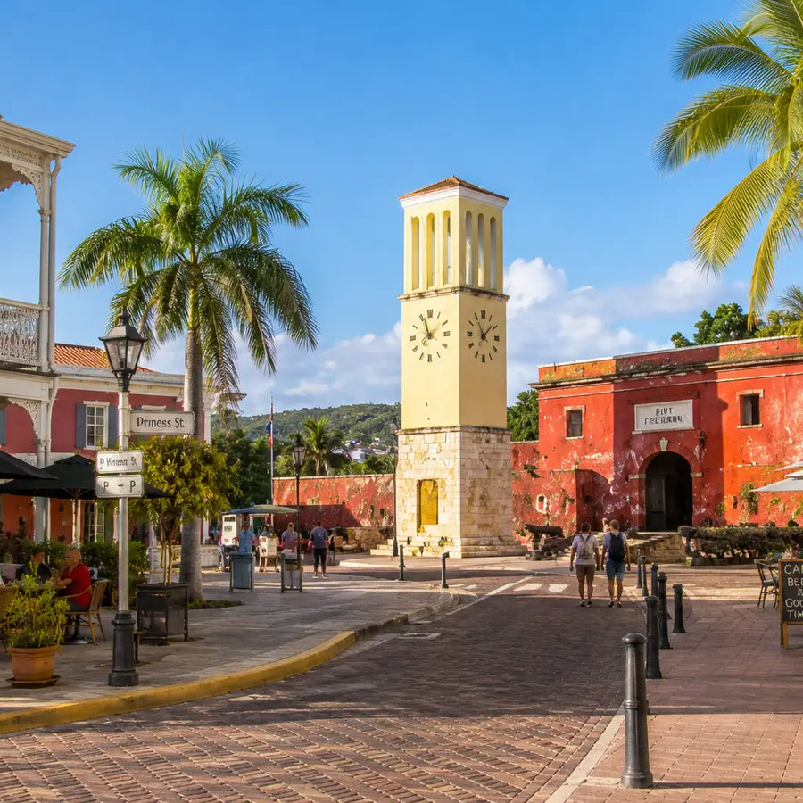 Colorful Danish colonial architecture, Fort Frederik, the historic clock tower, brick streets, palm trees, and outdoor cafés in Frederiksted, St. Croix, U.S. Virgin Islands.