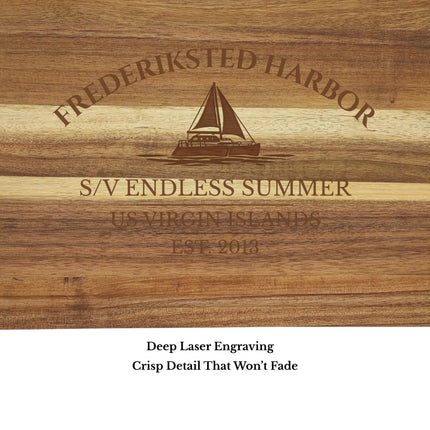 Close up of Frederiksted Harbor US Virgin Islands sailboat cutting board engraving showing detailed sailboat design and acacia wood grain