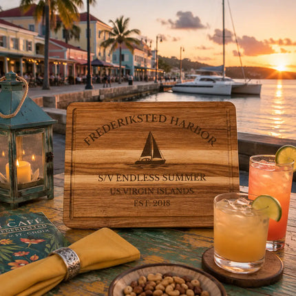 Frederiksted Harbor US Virgin Islands sailboat cutting board displayed beside a colorful Caribbean waterfront with palm trees sailboats and tropical sunset light on St Croix