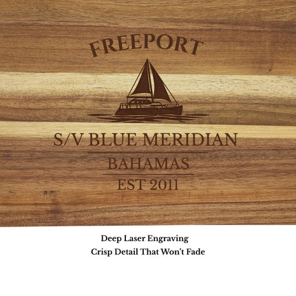 Close up of Freeport Bahamas sailboat cutting board engraving showing detailed sailboat design and acacia wood grain