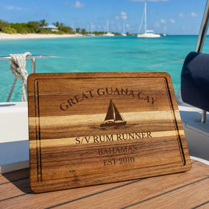 Great Guana Cay Bahamas sailboat cutting board overlooking calm turquoise anchorage water with tropical shoreline and anchored cruising sailboats in the Abacos