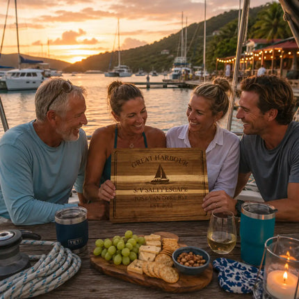 Great Harbour Jost Van Dyke British Virgin Islands personalized cutting board being shared during a relaxed Caribbean sailor gathering beside anchored catamarans and tropical harbor waterfront lights