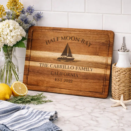 Half Moon Bay California sailboat cutting board displayed in coastal kitchen with lemons herbs and nautical decor