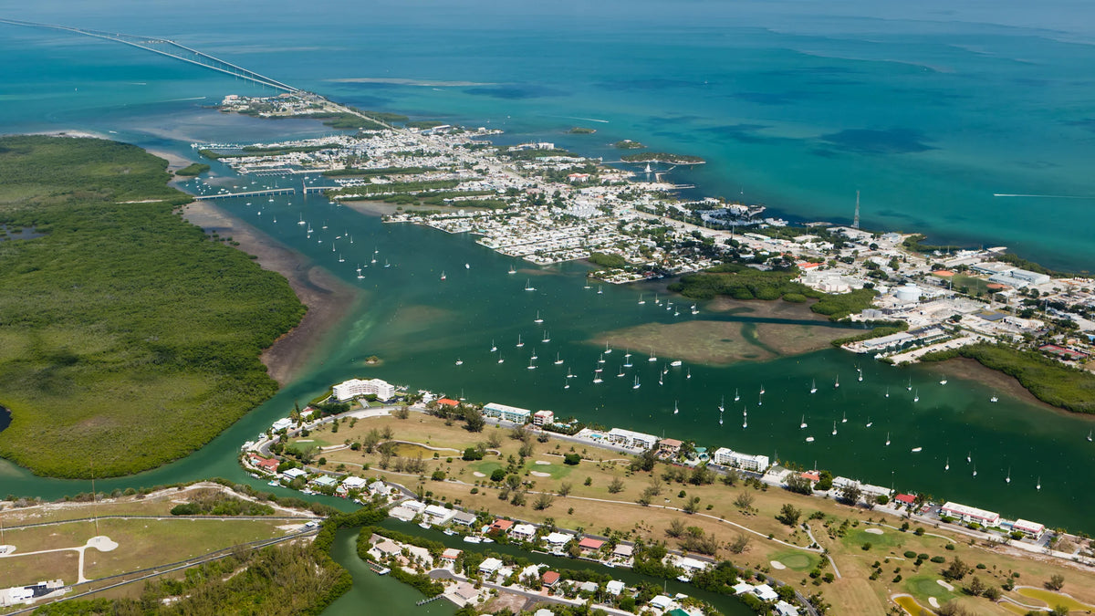 Aerial view of boats in Boot Key Harbor, mangrove shoreline and Marathon’s waterfront, with bridges extending across blue water.