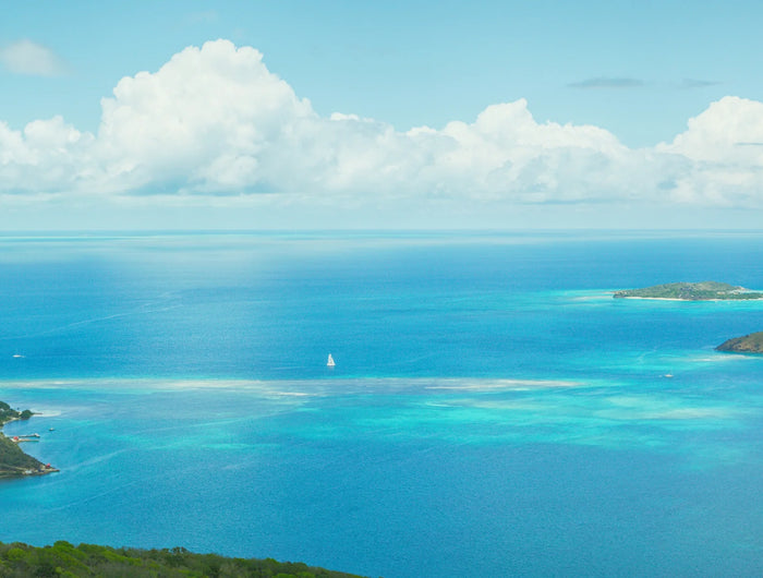 View across North Sound from Virgin Gorda, with turquoise water, small islands, and a sailboat.