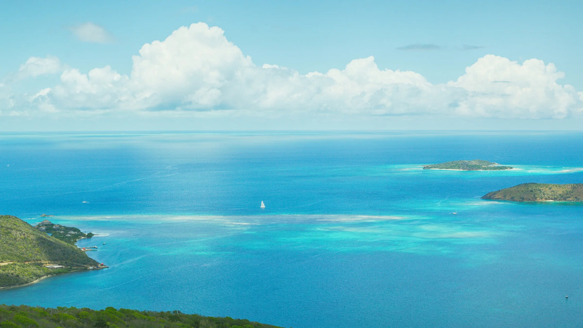 View across North Sound from Virgin Gorda, with turquoise water, small islands, and a sailboat.