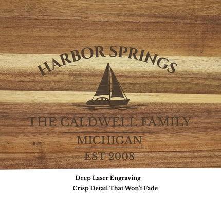 Close up of Harbor Springs Michigan sailboat cutting board engraving showing sailboat design custom boat name and engraved acacia wood detail