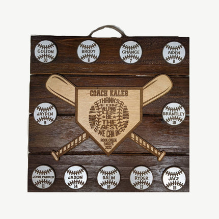 Wooden plaque with engraved text and baseball designs on a wooden background