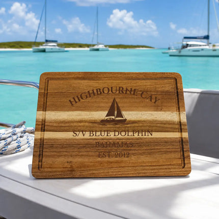 Highbourne Cay Bahamas sailboat cutting board overlooking crystal clear turquoise Exumas water with anchored catamarans and tropical island shoreline