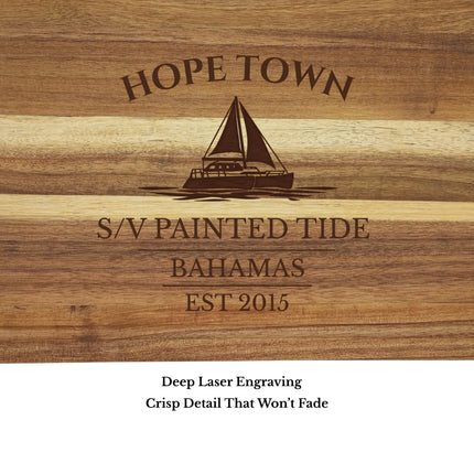 Close up of Hope Town Bahamas sailboat cutting board engraving showing detailed sailboat design and acacia wood grain