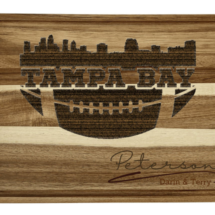 Custom Tampa Bay football cutting board featuring the city skyline and a football design. Personalized as requested to make a great gift.