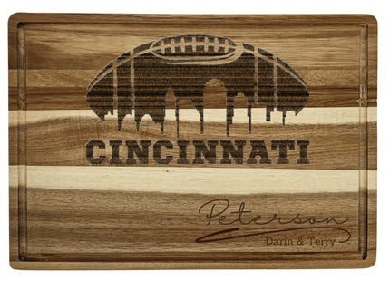 Custom Cincinnati football cutting board featuring the city skyline and a football design. Personalized as requested to make a great gift.