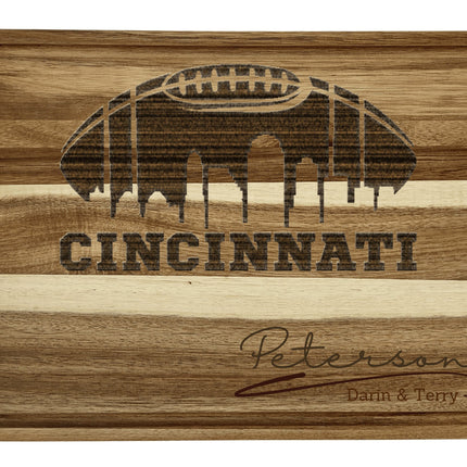 Custom Cincinnati football cutting board featuring the city skyline and a football design. Personalized as requested to make a great gift.