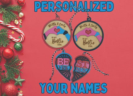 Festive holiday display of personalized wooden best friend ornaments on a red background. Two round ornaments read “Britta & Carly – In My Bestie Era,” and a colorful split heart ornament spells “Best Friends.” The left side of the image is decorated with pine branches, candy canes, red and green ornaments, and glittery stars. Blue text above and below the ornaments reads “PERSONALIZED YOUR NAMES.”