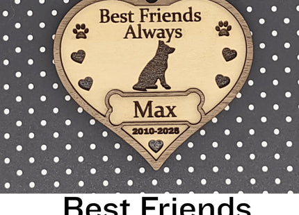 Heart-shaped wooden dog memorial ornament engraved with “Best Friends Always,” featuring a dog silhouette, paw prints, and hearts. The ornament includes the name “Max” and dates “2010–2025,” with a white ribbon for hanging, displayed against a black background with white polka dots. Text below reads “Best Friends Always.”