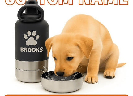 Golden puppy drinking water from a stainless steel bowl attachment next to a black and silver personalized pet water bottle labeled “BROOKS” with a paw print design. The scene is bright and clean, highlighting the product’s modern, travel-friendly design for pets.