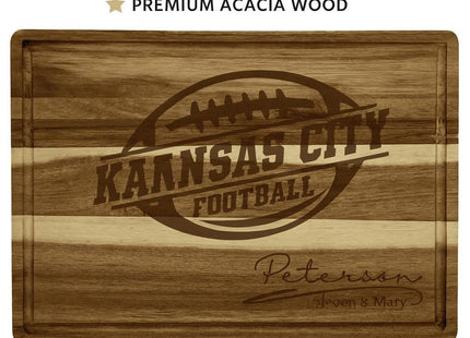 Custom acacia wood cutting board engraved with “Kansas City Football” inside a football logo and personalized text “Peterson – Steven & Mary” below. The image features bold text above reading “CUSTOM CUTTING BOARD ★ PREMIUM ACACIA WOOD” and below reading “PERSONALIZE WITH YOUR NAME.” The board showcases a striped woodgrain pattern with natural variations in tone.