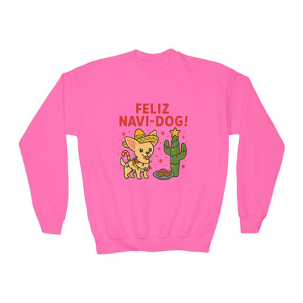 Bright pink crewneck sweatshirt featuring a festive “Feliz Navi-Dog!” Christmas design. The graphic shows a cheerful Chihuahua wearing a sombrero and scarf beside a cactus decorated like a Christmas tree with a star on top and a plate of cookies nearby. The phrase “FELIZ NAVI-DOG!” appears above the