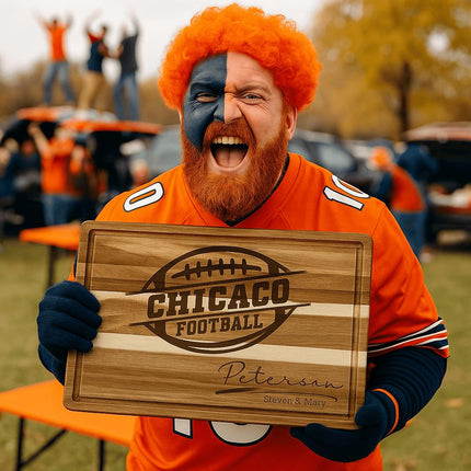 “Excited football fan with orange wig and face paint holding a personalized Chicago football cutting board at a tailgate party. The engraved acacia board features a football logo and the name ‘Peterson – Steven & Mary.’ The fan wears a bright orange jersey, surrounded by fellow supporters and tailgate tables in team colors.”