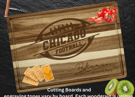 “Personalized Chicago football cutting board made from striped acacia wood, engraved with a football logo and the family name ‘Peterson – Steven & Mary.’ Board displayed on a dark slate surface with food items including tomatoes, crackers with cheese, and sliced kiwi. Text below reads ‘Cutting boards and engraving tones vary by board. Each woodgrain is unique.’”