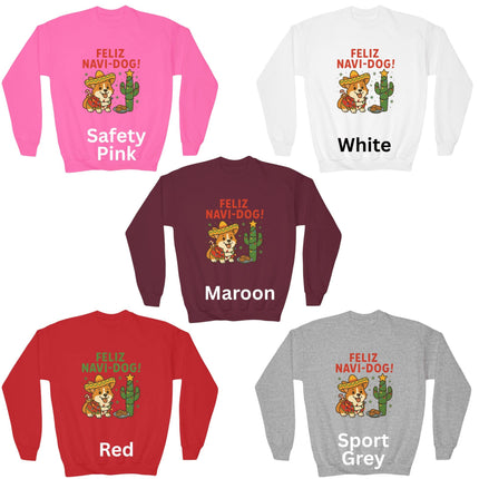 Five “Feliz Navi-Dog!” Christmas sweatshirts displayed in different colors — Safety Pink, White, Maroon, Red, and Sport Grey. Each sweatshirt features a festive Corgi wearing a sombrero and poncho beside a cactus decorated like a Christmas tree with a star on top and cookies nearby. The text “FELIZ NAVI-DOG!” appears above the graphic in bold letters.