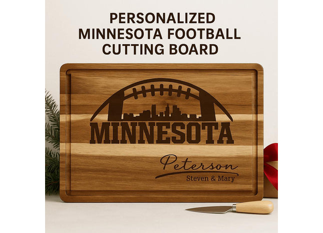 &quot;Personalized Minnesota football cutting board made of striped acacia wood with engraved football and city skyline design. The engraving reads &#39;MINNESOTA&#39; with the family name &#39;Peterson&#39; and &#39;Steven & Mary&#39; below. Displayed with a small cheese knife and red ribbon, set against a clean neutral background with evergreen accents.&quot;