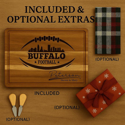 "Buffalo football personalized cutting board shown with included and optional extras. The board is engraved with a football and city skyline design, plus a custom family name. Displayed with two optional cheese spreader knives, an optional plaid kitchen towel, and an optional red gift box with snowflake pattern and ribbon. Text reads 'Included & Optional Extras' on a wooden background."